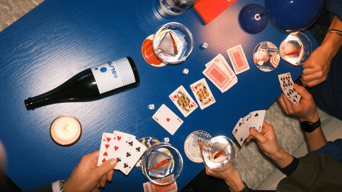 Spelkväll hemma med drinkar och spelkort — bubbel som alltid finns nära